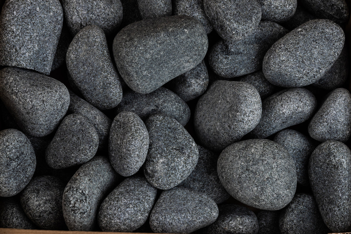 Close up of rounded olivine sauna stones