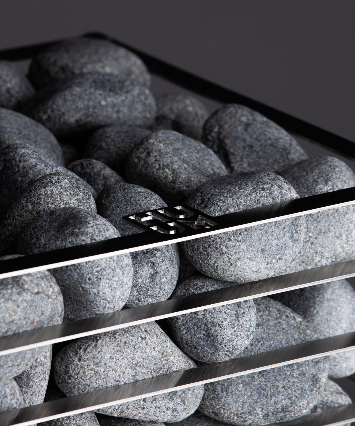 HUUM olivine diabase sauna stones loaded in the basket of a HUUM CLIFF heater