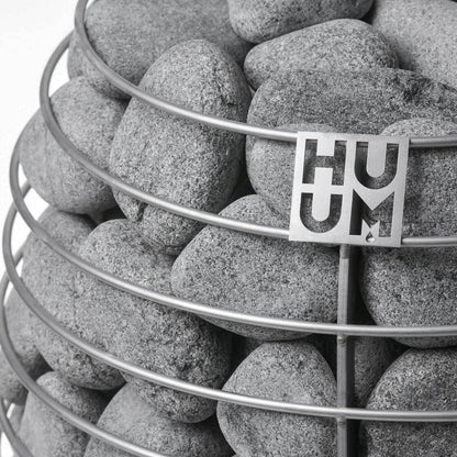HUUM sauna stones in the open cage of a HUUM heater