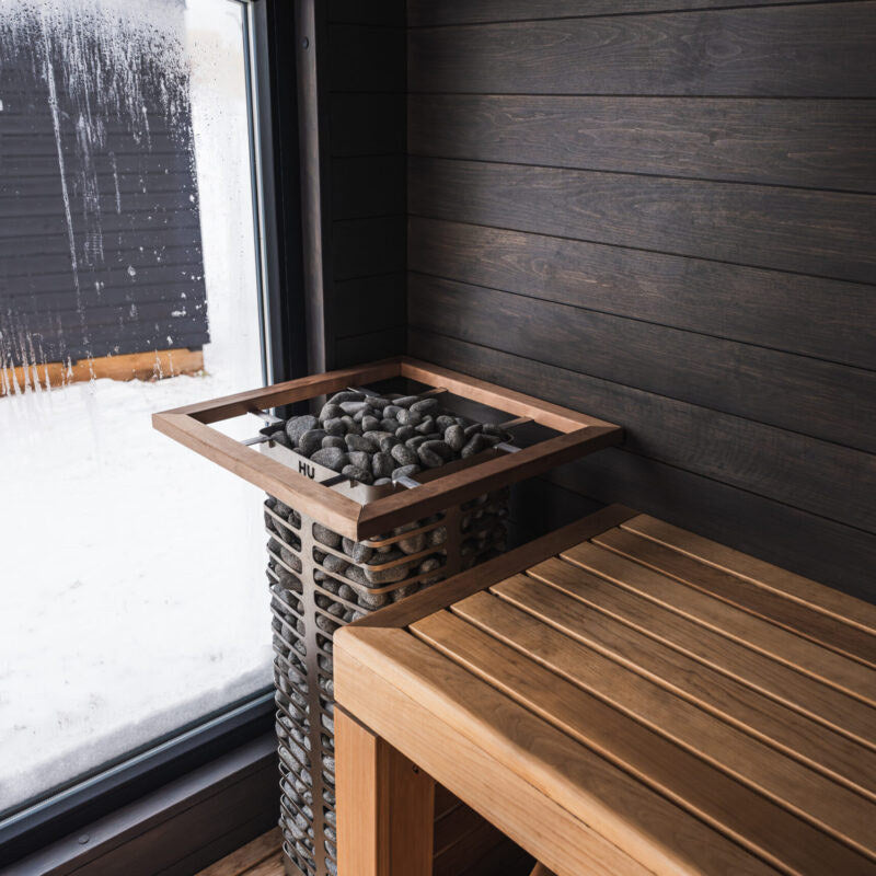 HUUM STEEL heater with safety rail by a sauna window