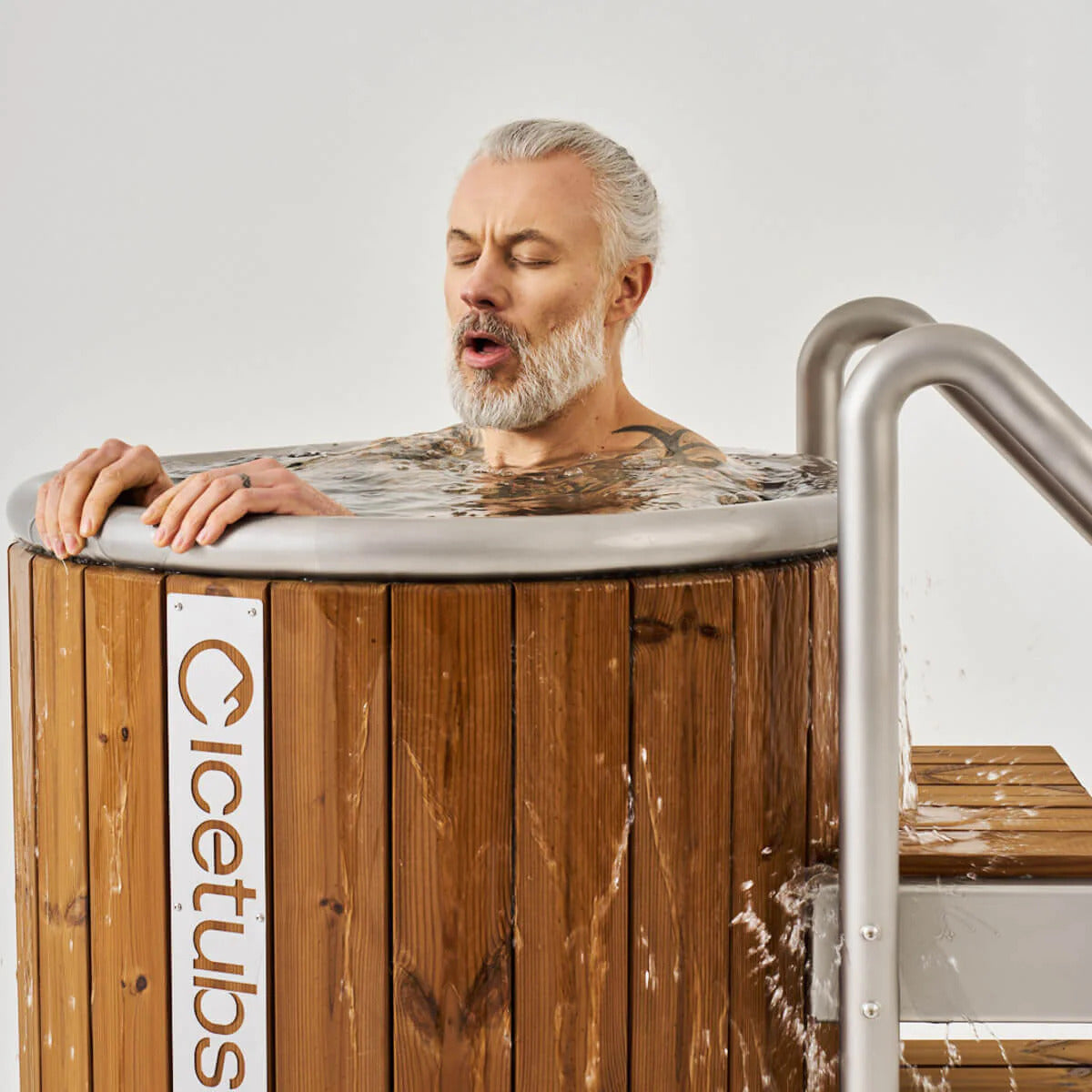Icetubs IceBarrel Thermowood & Stainless Steel Cold Plunge Tub, bather submerged to the shoulders with the stainless rim in frame