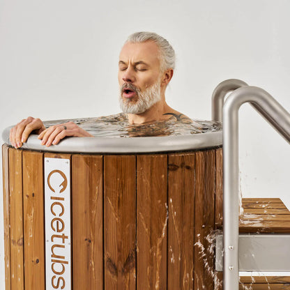 Icetubs IceBarrel Thermowood & Stainless Steel Cold Plunge Tub, bather submerged to the shoulders with the stainless rim in frame