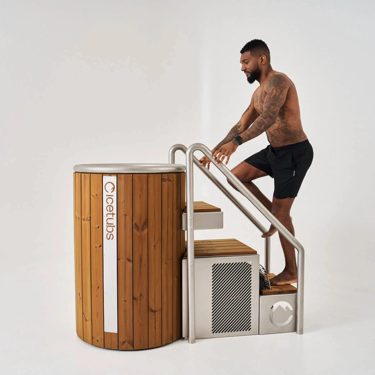 Icetubs IceBarrel Thermowood & Stainless Steel Cold Plunge Tub, bather stepping in using the optional stairs over the engine