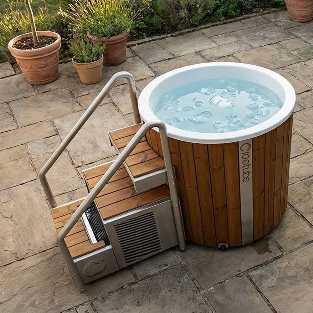 Icetubs IceBarrel XL Thermowood & Fiberglass Cold Plunge Tub, filled and running on a paved patio with the stairs fitted