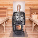 TimberGlow14 wood-burning stove with fire lit, chimney pipe and floor plate inside a cedar barrel sauna