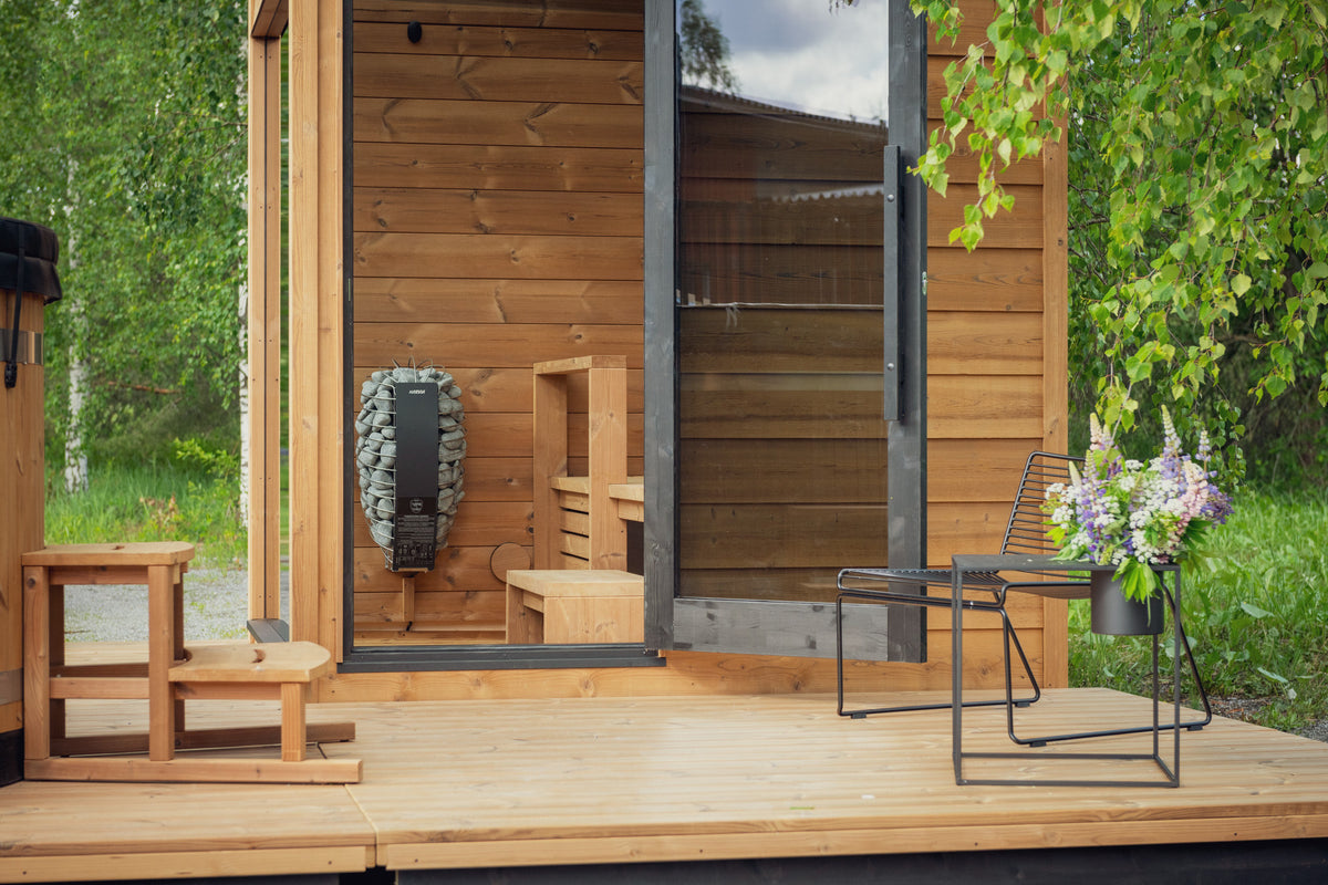 ThermaSol Nordic Dawn outdoor sauna cabin seen from the deck, glass front and heater