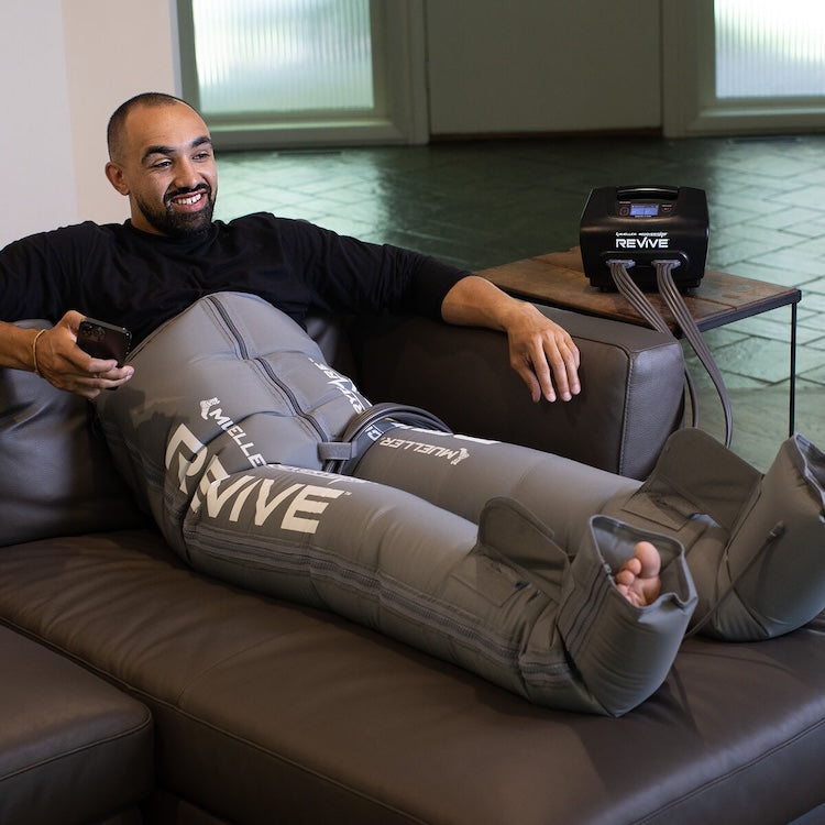 Mueller REVIVE Compression Pants in use — full-leg coverage recovery session