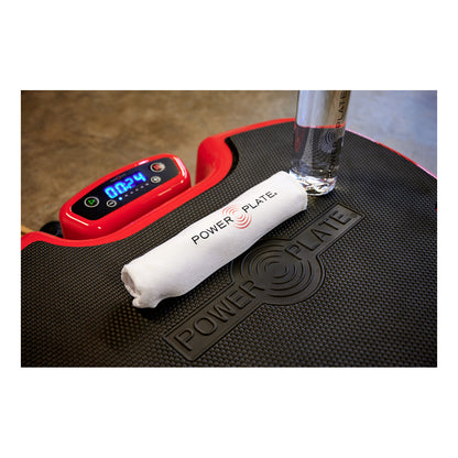 Power Plate MOVE console timer running beside a towel and water bottle on the platform mat