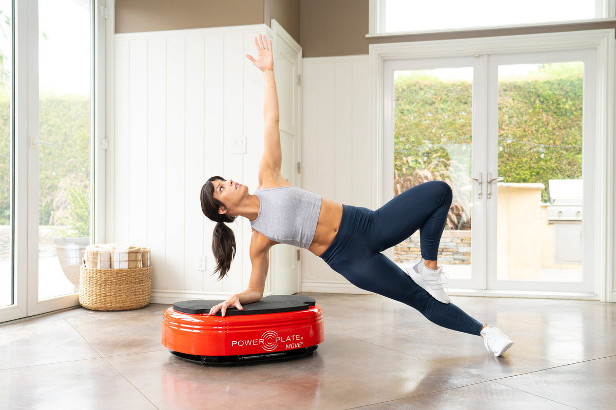 Woman in a side plank with one hand on the red Power Plate MOVE