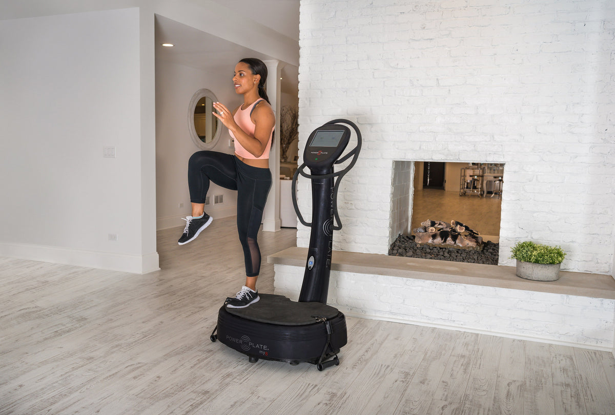 Woman lifting one knee while balancing on the Power Plate my8 platform