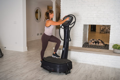 Woman with one foot on the Power Plate my8 platform, reaching for the touchscreen
