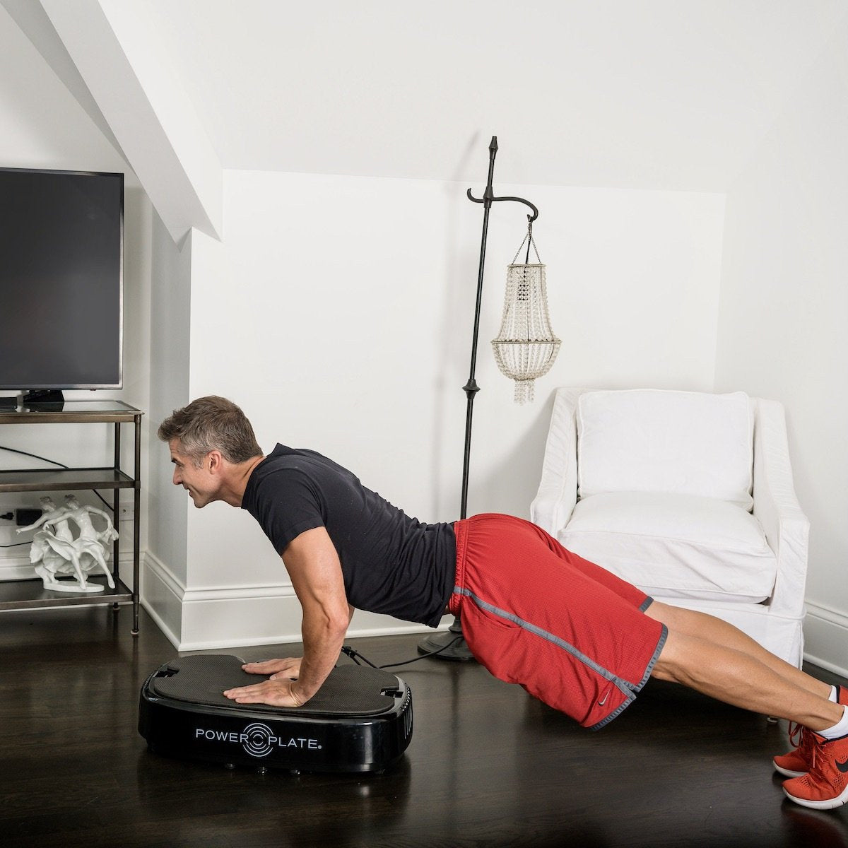 Man doing a push-up with his hands on the Personal Power Plate