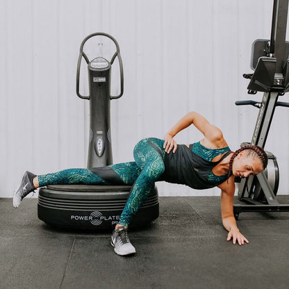 Woman doing a side plank variation with her legs on the Power Plate pro5 platform