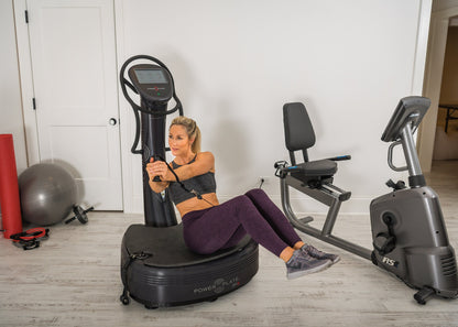 Woman in a seated position on the Power Plate pro8 platform, pulling a proMOTION cable across her body