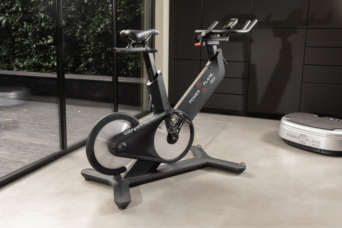 Power Plate REV in matte black standing in a home gym
