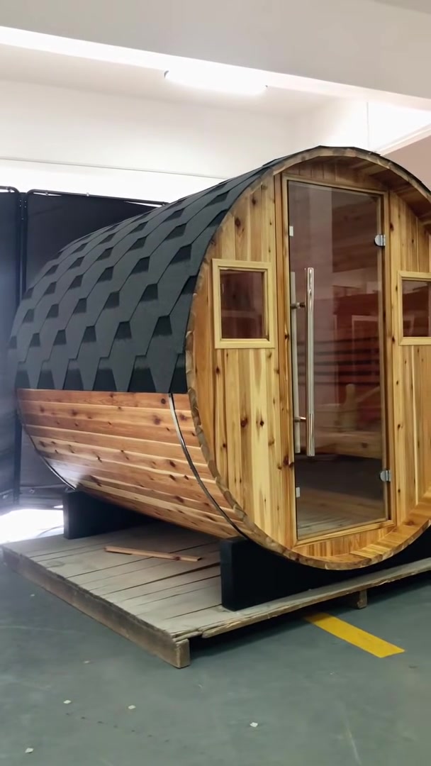 SunRay barrel sauna walkaround film in western red cedar: shingled roof, glass door and windows, then the heater and benches inside
