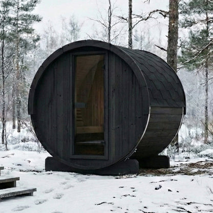 SaunaLife E6 Ergo Series 3-Person Outdoor Barrel Sauna Kit, black finish, in snow beside a cabin