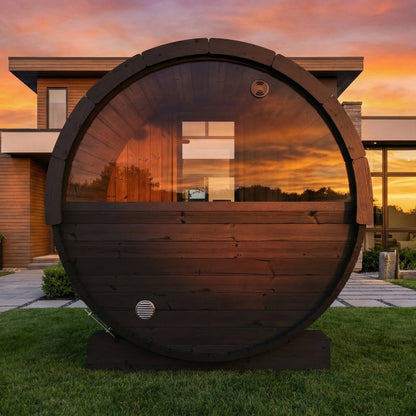 SaunaLife E6W Ergo Series 3-Person Outdoor Barrel Sauna Kit, Rear Window, black finish, on a lawn at sunset