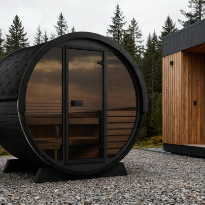 SaunaLife EE6G Ergo Elegance 4-Person Outdoor Barrel Sauna Kit, Glass Front, black finish, on a coastal deck at dusk