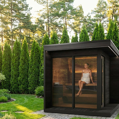 SaunaLife GL6 Garden Luxury 6-Person Outdoor Sauna Kit, black finish, in a garden with conifers
