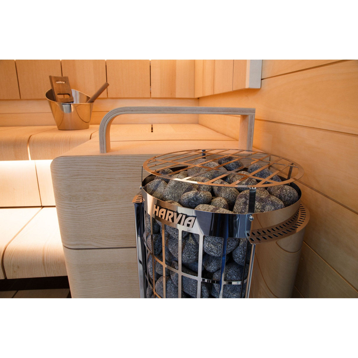Harvia Cilindro sauna heater with its timber guard, standing beside the sauna bench