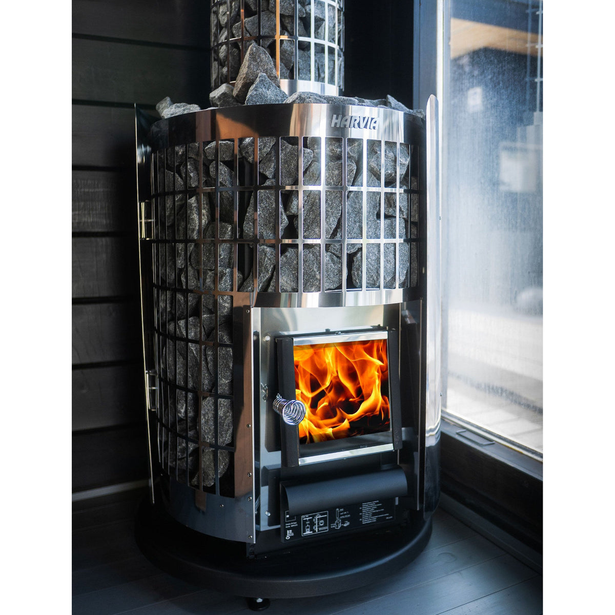 Fire burning behind the glass door of the Harvia Cilindro wood stove
