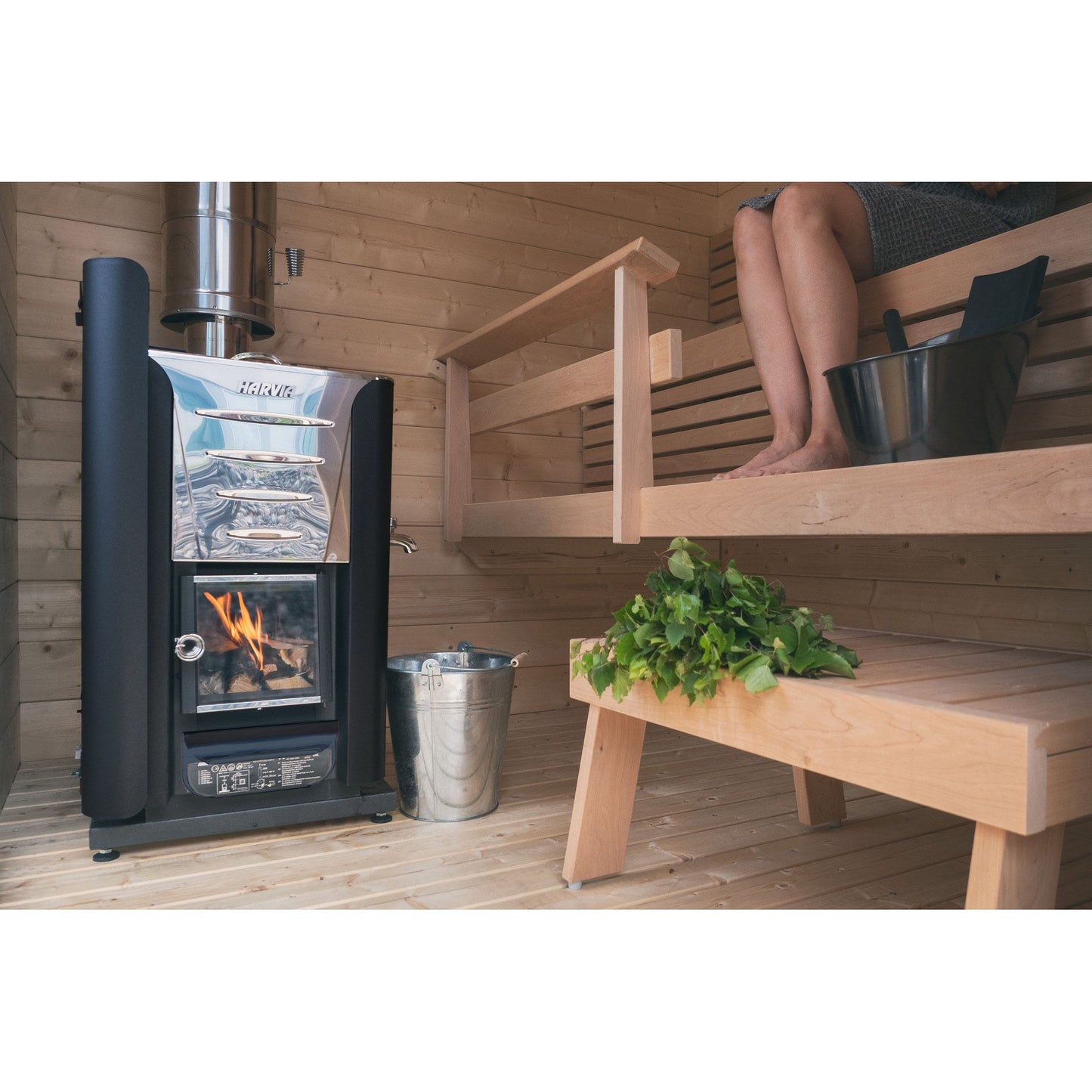 Harvia Pro wood stove in a sauna with bucket, ladle and birch whisk