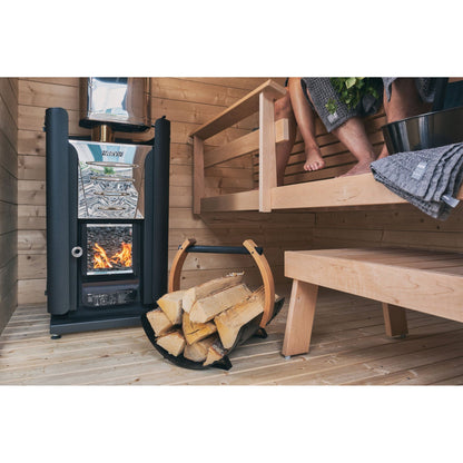 Harvia Pro wood-burning sauna stove beside the bench with firewood stacked