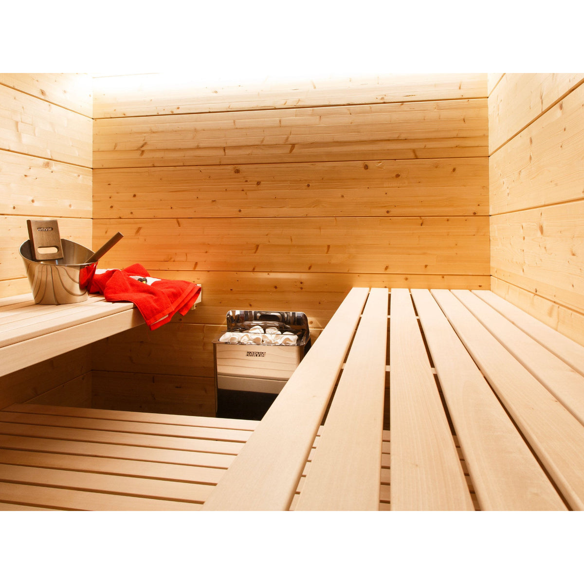 Harvia The Wall stainless steel sauna heater beside timber sauna benching