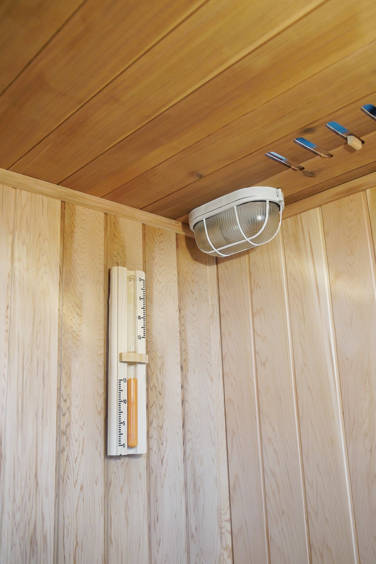 Sand timer on the wall below the caged ceiling light and vent inside the SunRay Aston