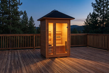 SunRay Bristow outdoor sauna on a wooden deck at dusk, lit interior behind the glass door and front window