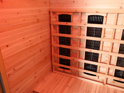 Back corner of the SunRay Burlington interior: hemlock walls and infrared heater panels behind the backrest slats