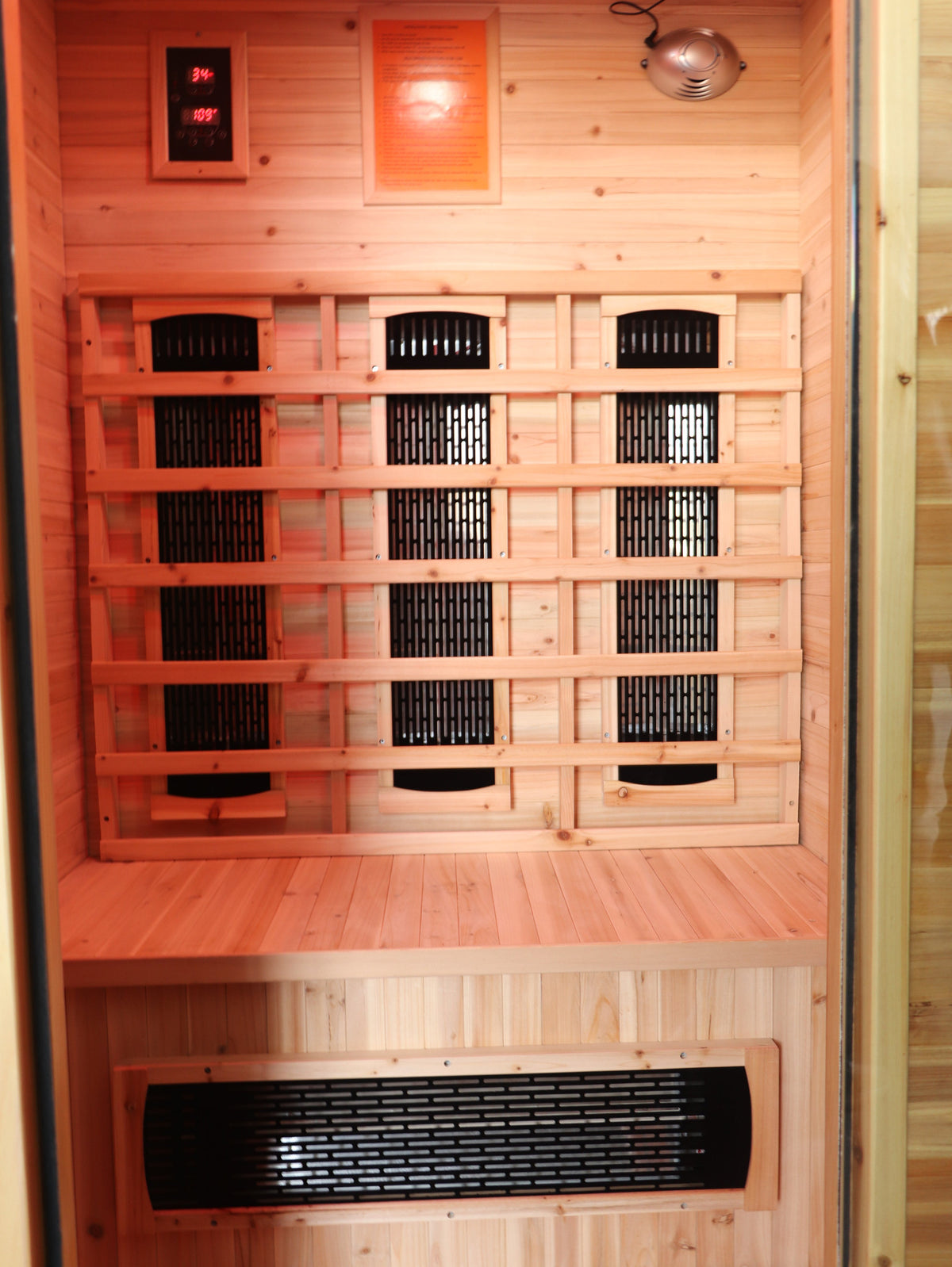 Inside the SunRay Burlington through the open door: infrared heater panels behind the backrest and in the bench front, control panel at the top left