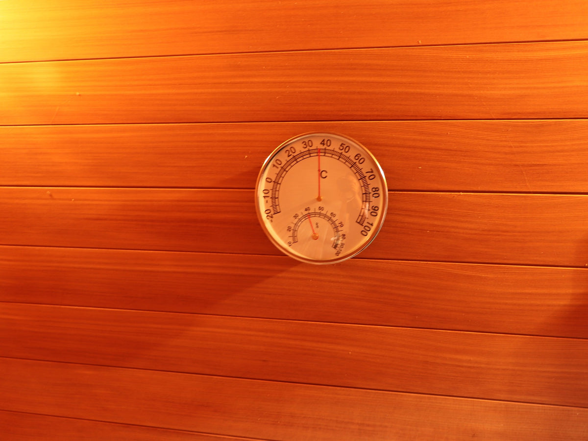Round thermometer and hygrometer dial on the hemlock wall inside the SunRay Cayman