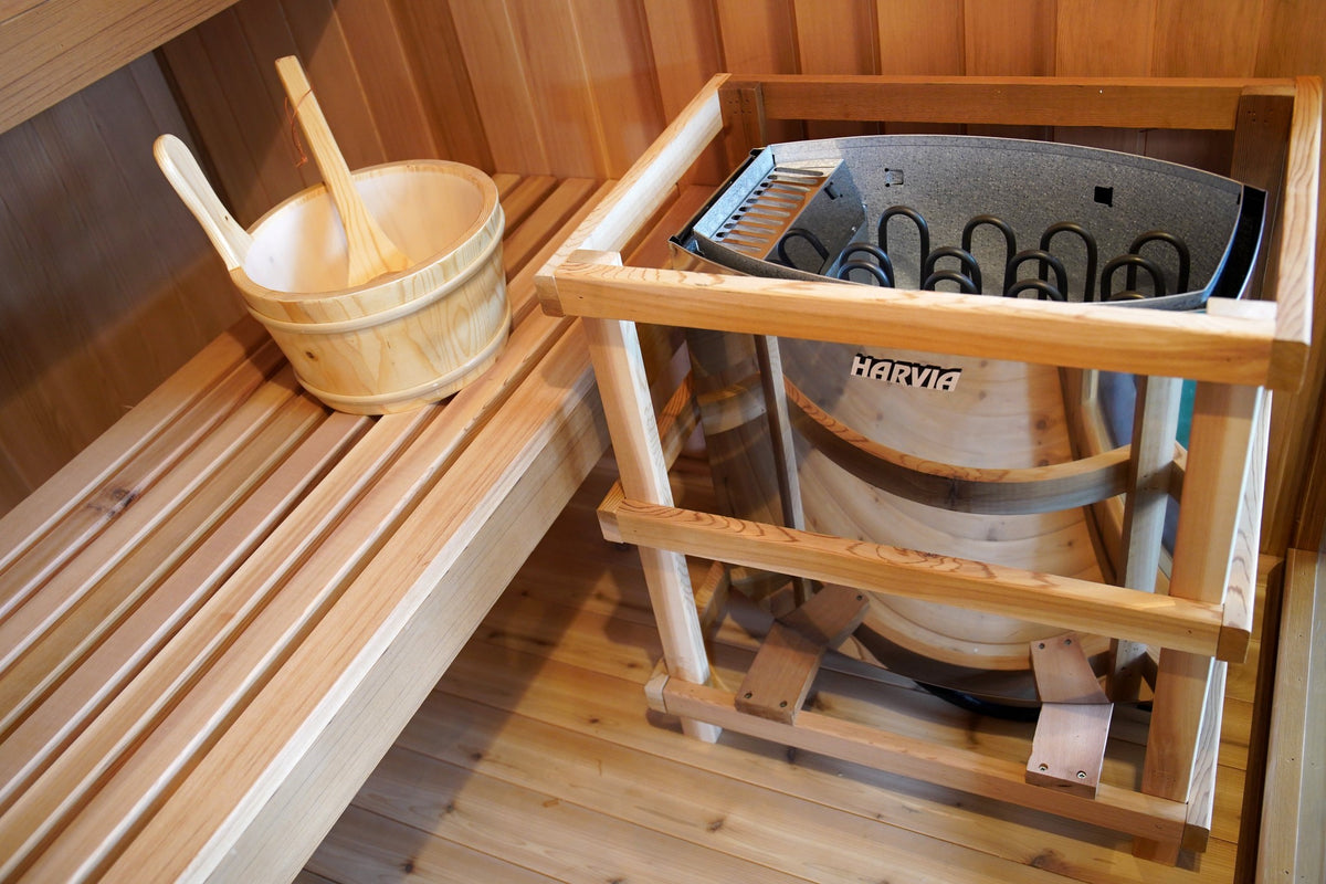 Harvia heater in its wooden guard rail beside the bench and bucket inside the SunRay Charleston