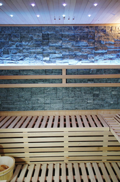 Two-tier benches below the lit stone back wall and ceiling downlights inside the SunRay Galaxie