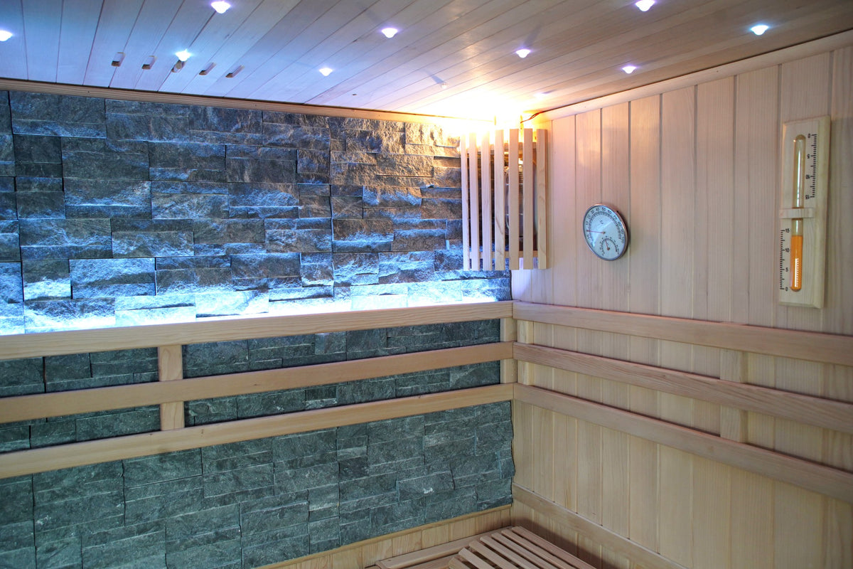 Ceiling downlights, slatted wall light, hygrometer and sand timer beside the stone wall inside the SunRay Galaxie