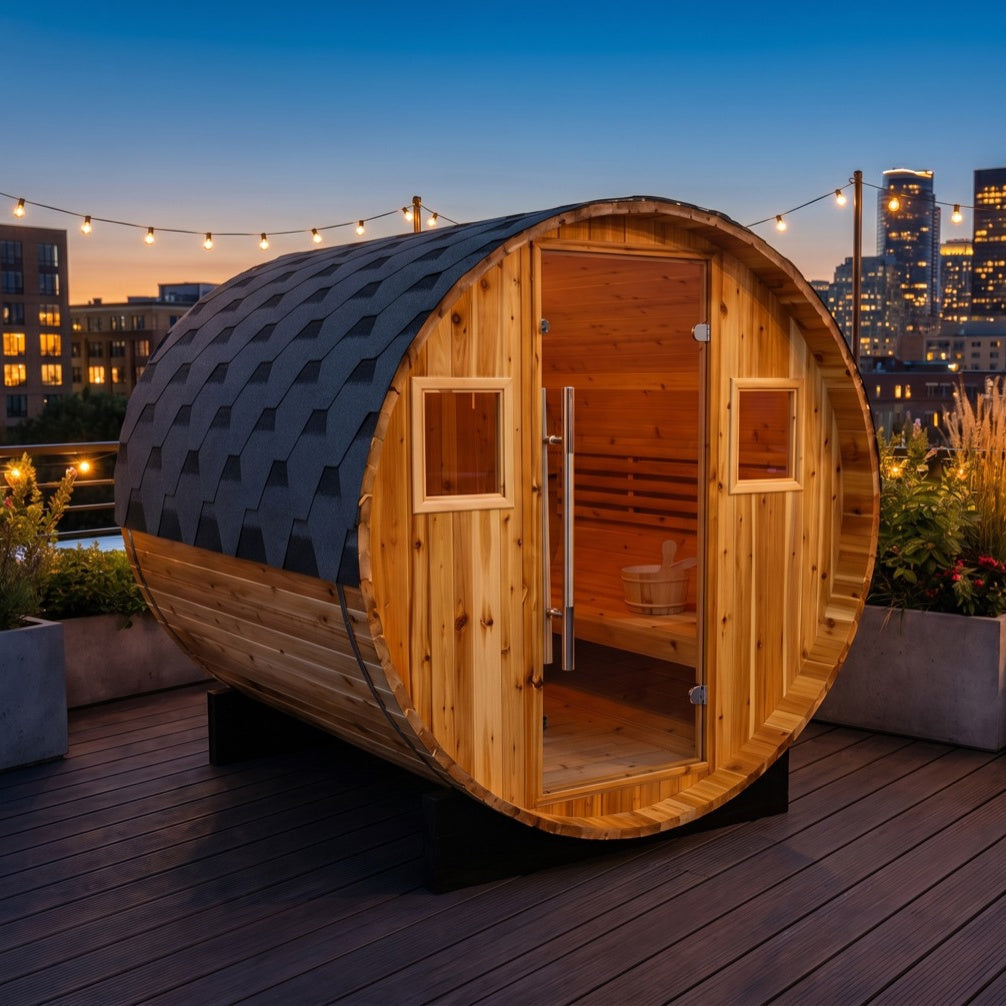SunRay Galley barrel sauna for 4 in western red cedar, glass door between two small windows along the long shingled roof, on a rooftop deck with string lights and city lights at dusk