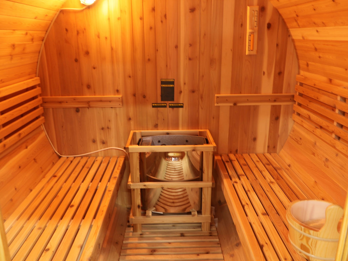 SunRay Galley interior: heater inside its guard rail between two long cedar benches, wooden bucket on the right