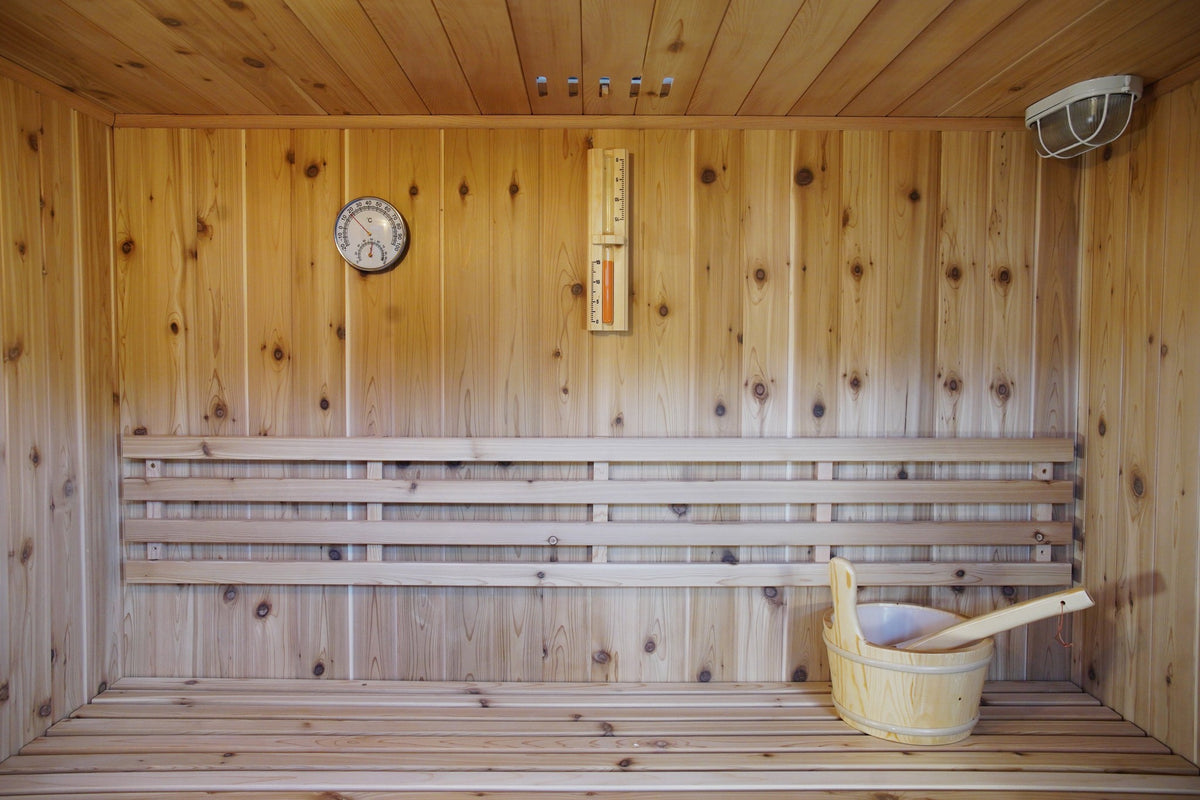 Back wall inside the SunRay Hampton: backrest, hygrometer, sand timer, ceiling vent and light, bucket on the bench