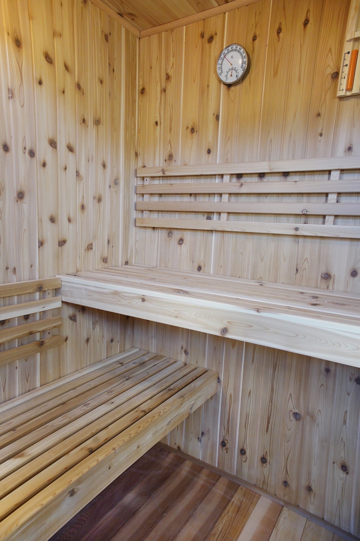 Two-tier corner benches and backrest inside the SunRay Hampton, hygrometer on the back wall