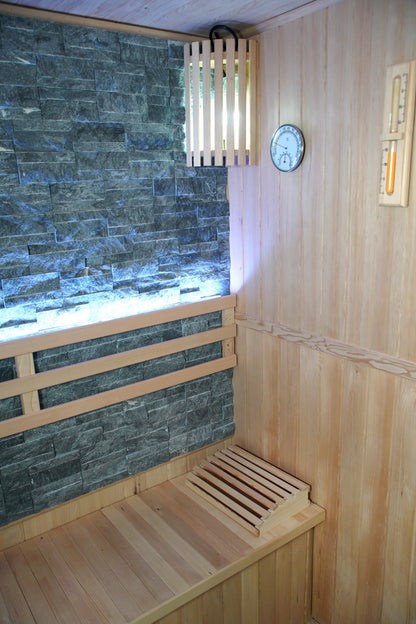 Corner of the SunRay Rockledge: stone wall with backrest, slatted wall light, hygrometer, sand timer and headrest on the bench