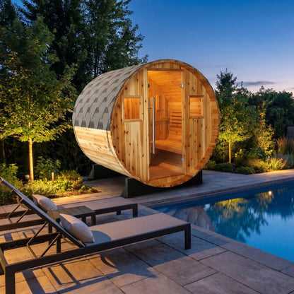 SunRay Solace barrel sauna for 2 in western red cedar, glass door between two small windows under the shingled roof, beside a lit pool and loungers at dusk