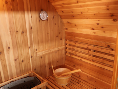 Corner of the SunRay Solace interior with the wooden bucket and ladle on the bench and the thermometer and hygrometer on the wall