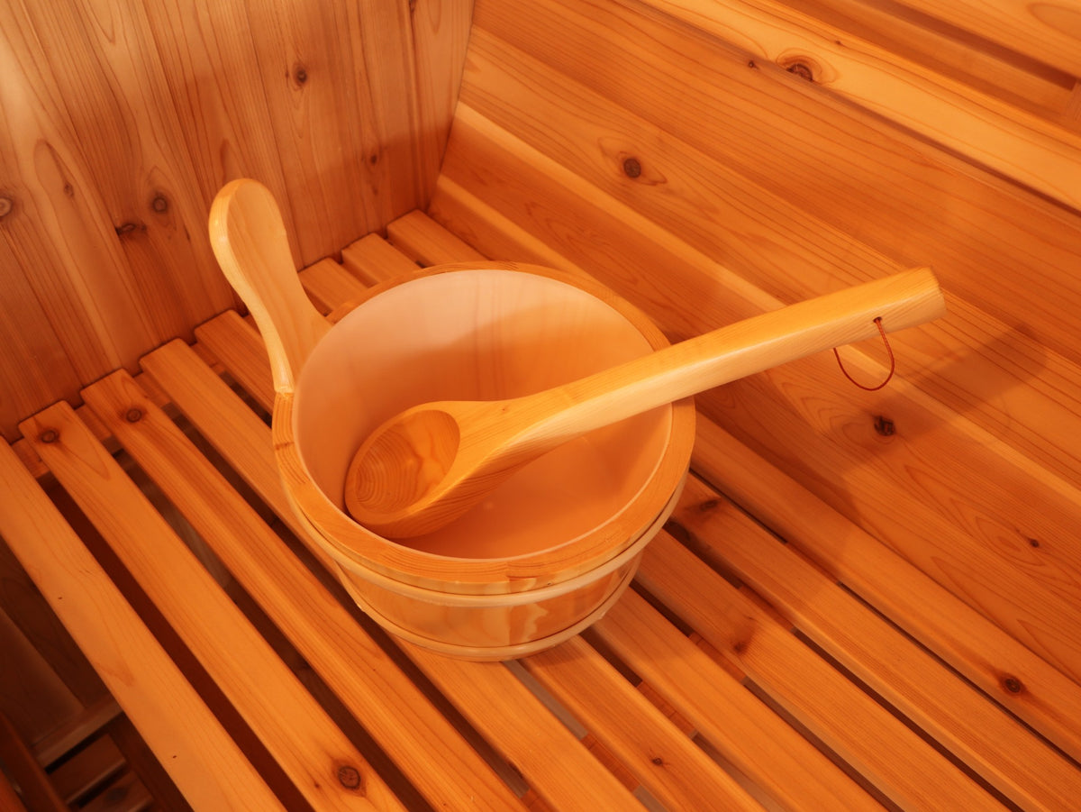 Wooden bucket and ladle on a cedar bench inside the SunRay Solace