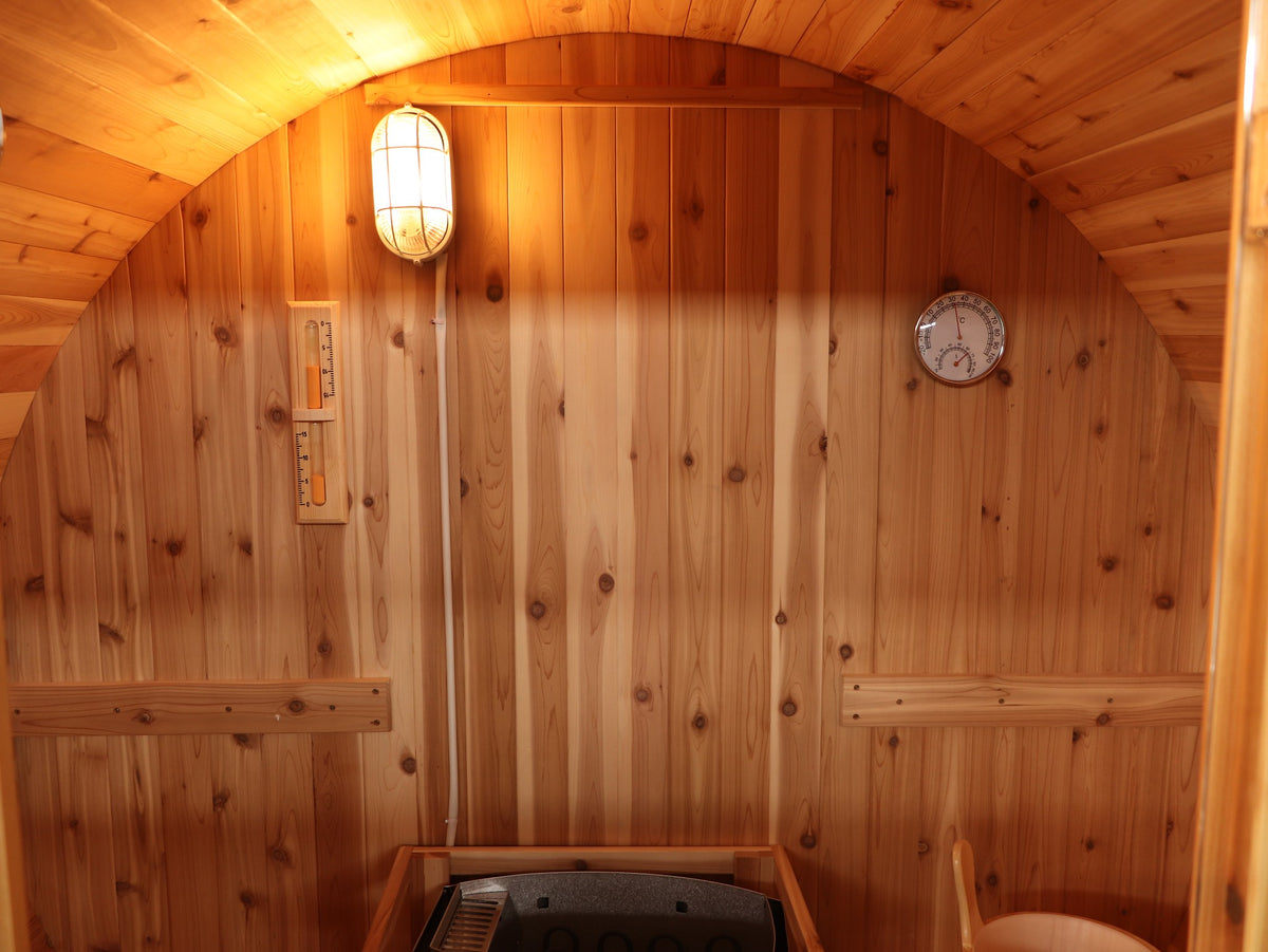 Inside the SunRay Solace: western red cedar back wall with light, sand timer, thermometer and hygrometer above the backrests
