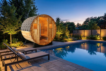 SunRay Solace barrel sauna in western red cedar beside a pool at dusk: glass door between two small windows under the shingled roof, loungers on the pool deck