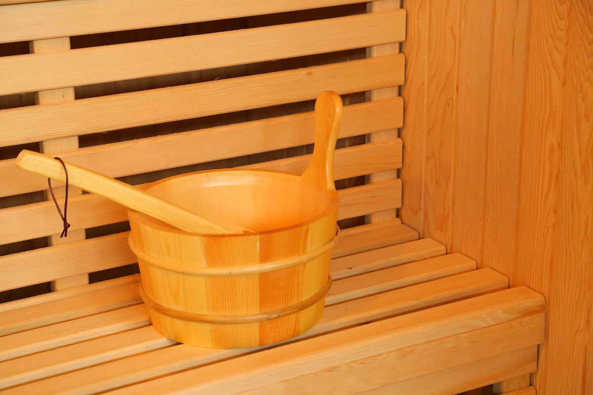 Wooden bucket and ladle on the slatted bench inside the SunRay Southport, with the backrest behind
