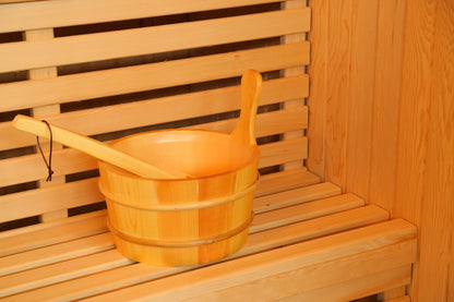 Wooden bucket and ladle on the slatted bench inside the SunRay Southport, with the backrest behind