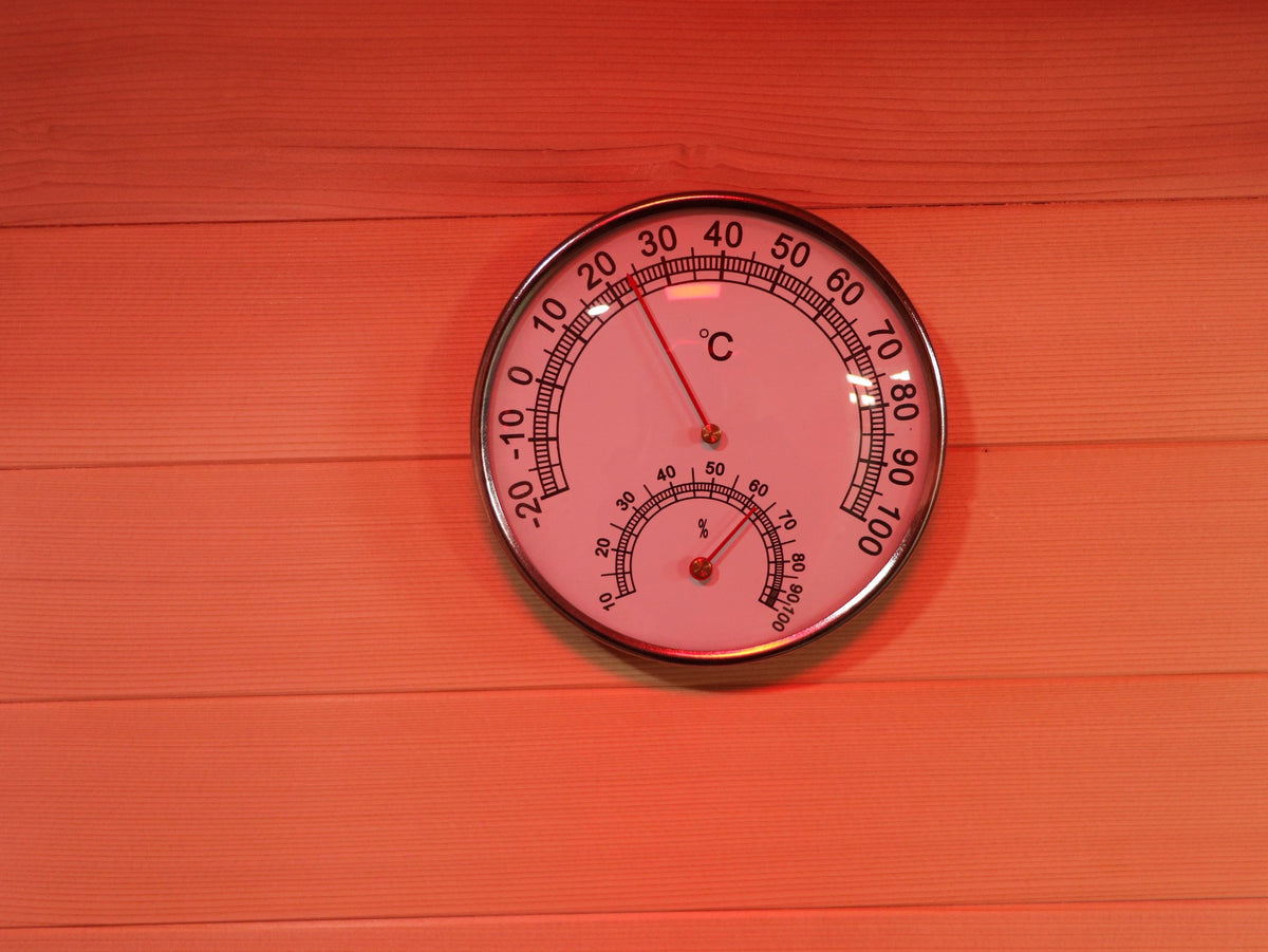 Round thermometer and hygrometer dial on the hemlock wall inside the SunRay Waverly (interior shared with the Freeport)